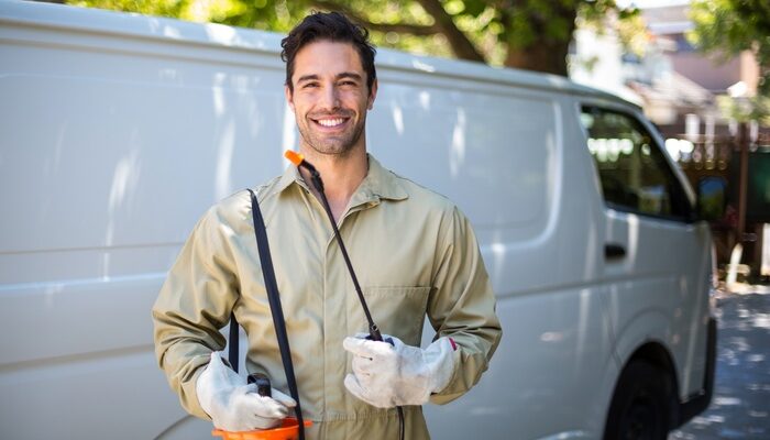 Smiling worker with pesticide sprayer